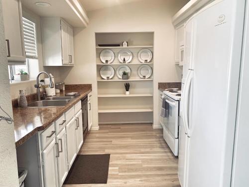 a kitchen with white cabinets and a sink and a refrigerator at THE ACE OF OASIS - Casual And Serene Vacation Home in Lake Havasu City