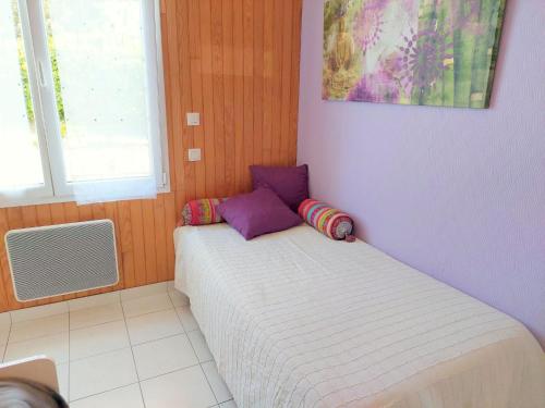a small bed in a room with purple walls at Cottage, Plouescat in Plouescat