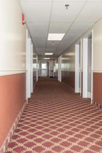 an empty hallway in an office building with a carpeted floor at Eastbrook Inn in Ronks