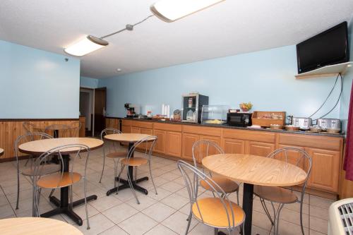 a room with tables and a kitchen with a tv at Eastbrook Inn in Ronks