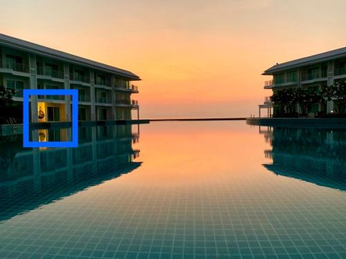 a view of a swimming pool at sunset at On-the-Beach Seaview With Direct Pool Access - 1 Bedroom by Sweethome in Ban Bo Khaem