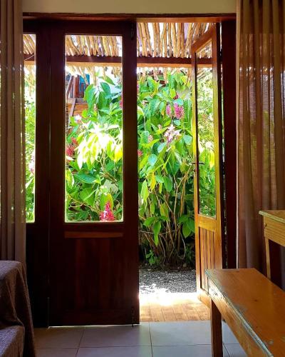 an open door with a view of a garden at Vila Hibisco Itacaré in Itacaré