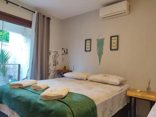 a bedroom with a bed with two towels on it at Apartamento na Praia do Amor-Pipa in Pipa