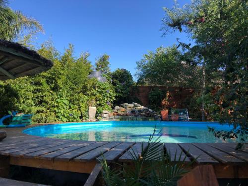 a swimming pool in a yard with a wooden deck at Posada Agua Marina in La Paloma
