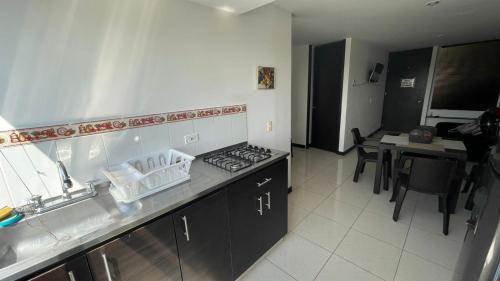 a kitchen with a sink and a stove top oven at Guaduales del café a 403 in Montenegro