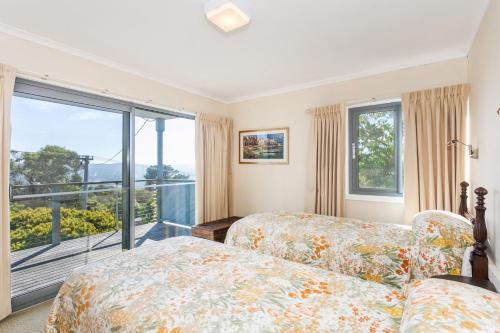 a bedroom with two beds and a balcony at Anglesea Outlook in Anglesea