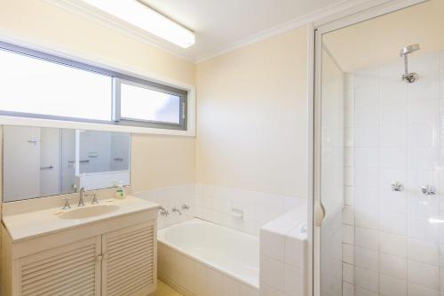 a bathroom with a tub and a sink and a shower at Anglesea Outlook in Anglesea