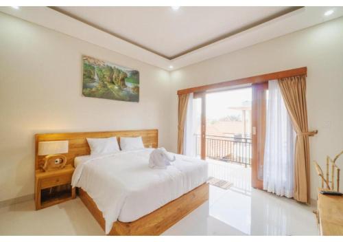 a bedroom with a bed and a large window at Komala Homestay in Canggu