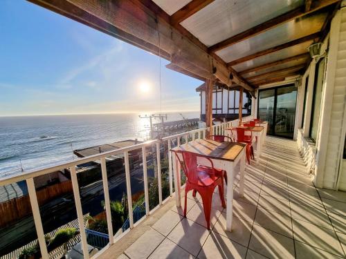 balcón con mesa y sillas y vistas al océano en Quinto Sol B&B, en Viña del Mar