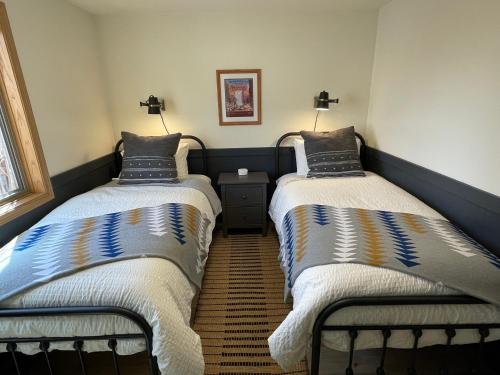 two twin beds in a room with at Pinedale Cozy Cabins in Pinedale