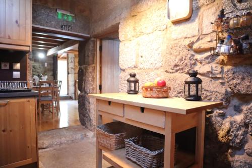uma cozinha com uma mesa com um cesto de frutas em Comfortable rural cottage in ancient village in the Douro region em Viseu