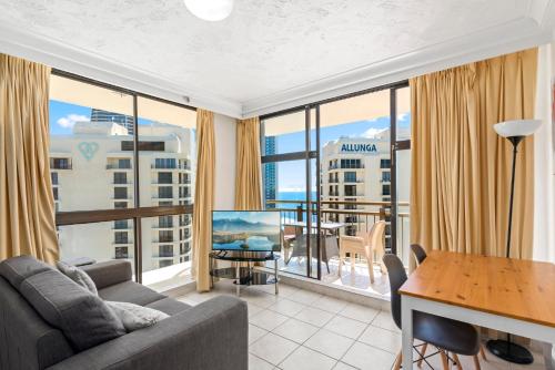 a living room with a couch and a table at Beachcomber Resort - Official in Gold Coast