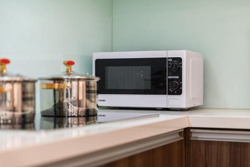 a white microwave sitting on top of a counter at Nesta - The Grand Hao Nam in Hanoi
