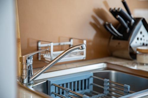 a kitchen sink with a dish drying rack next to it at Nesta - The Grand Hao Nam in Hanoi