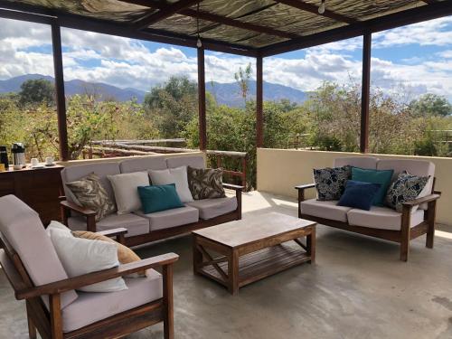 a patio with couches and tables and a view of mountains at Bubezi Camp in Mafuta