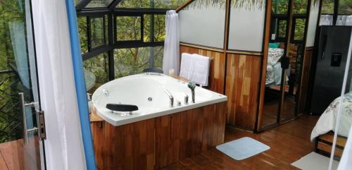 ein Bad mit einem Waschbecken in einem Zimmer mit einem Fenster in der Unterkunft Cristal House Mountain View in Heredia
