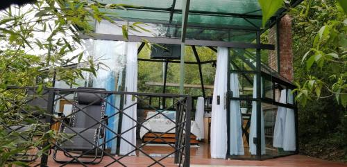 eine Glaserweiterung zu einem Haus mit einer Terrasse in der Unterkunft Cristal House Mountain View in Heredia