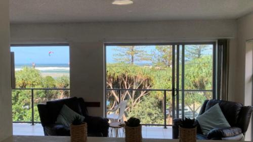 a living room with two chairs and a view of the ocean at #3 Moondara, Bulcock Beach Esplanade W - View in Caloundra
