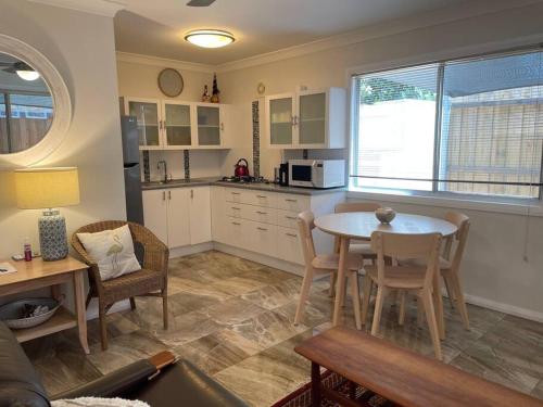 a kitchen and living room with a table and chairs at Patonga Street Retreat in Patonga