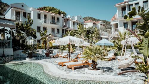 a pool at a hotel with chairs and umbrellas at Salonika Suites in Oludeniz