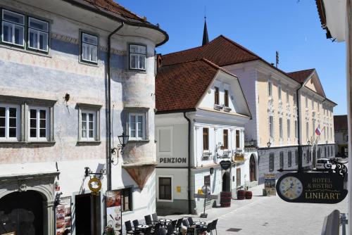 a group of buildings with a clock on a street at Hiša Linhart, Hotel & Restaurant in Radovljica