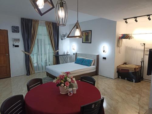 een slaapkamer met een bed en een tafel met bloemen erop bij Haji Ineng Homestay- Guest House in Kota Samarahan