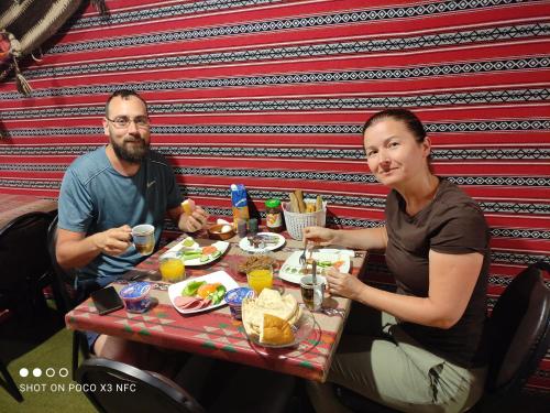 a man and woman sitting at a table eating food at Majido Hotel in Wadi Musa