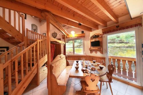 une salle à manger avec une table et un escalier dans l'établissement Le Bucheron au cœur du massif des Vosges 3 étoiles, à Gérardmer