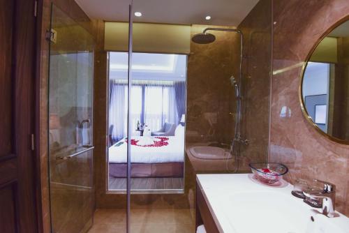 a bathroom with a shower and a bedroom with a bed at Phu Cuong Hotel Ca Mau in Cà Mau