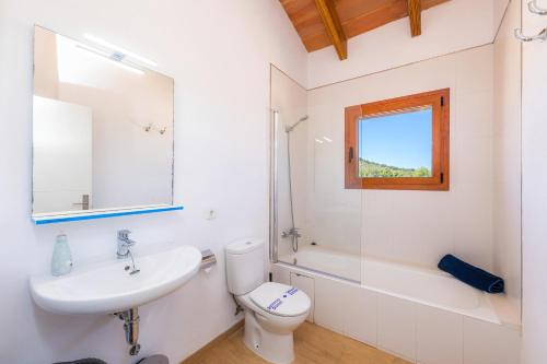 uma casa de banho com um lavatório, um WC e um espelho. em Pula Rustic em Cala Bona