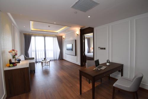 a living room with a table and a desk at Phu Cuong Hotel Ca Mau in Cà Mau