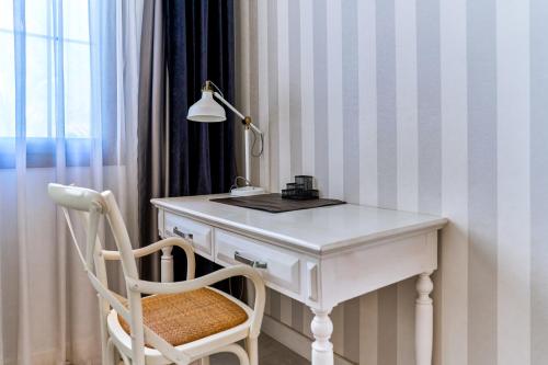 a white desk with a lamp and a chair at Salonika Suites in Oludeniz
