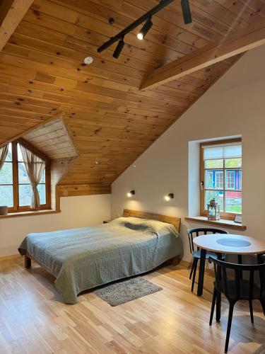 a bedroom with a large bed and a table at Apartamentai Gėlių Vila in Nida