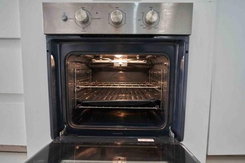 an oven with its door open in a kitchen at Exclusivo y acogedor con ascensor Directo en Urbanización la Merced in Trujillo