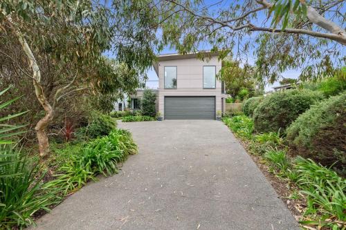 a house with a garage with a driveway at Aireys Delight in Aireys Inlet