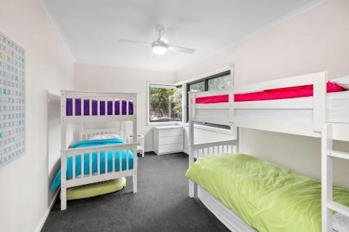 a room with two bunk beds and a window at Aireys Delight in Aireys Inlet
