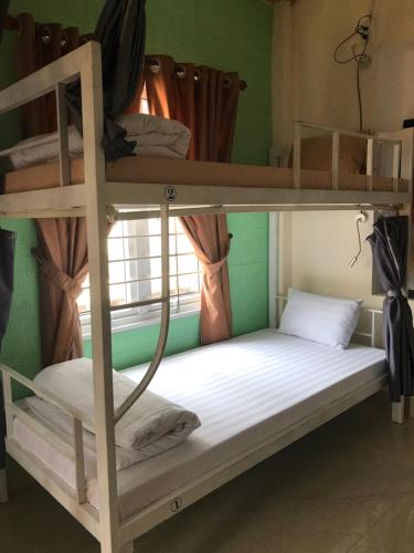 two bunk beds in a room with a window at Maily Hostel in Hue
