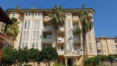 a large building with palm trees in front of it at İSABELLA APART OTEL in Alanya