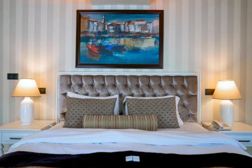 a bedroom with a bed with a painting above it at Salonika Suites in Oludeniz