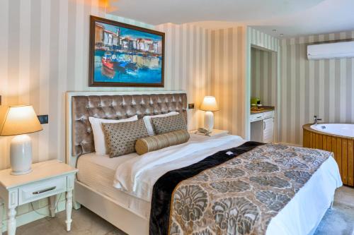 a bedroom with a large bed and a bath tub at Salonika Suites in Oludeniz