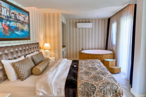 a bedroom with a large bed and a bathroom at Salonika Suites in Oludeniz