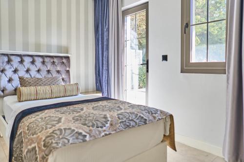 a bedroom with a bed and a window at Salonika Suites in Oludeniz