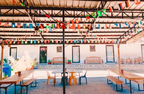 a large room with tables and chairs and flags at The Hangover Hostel in Moalboal