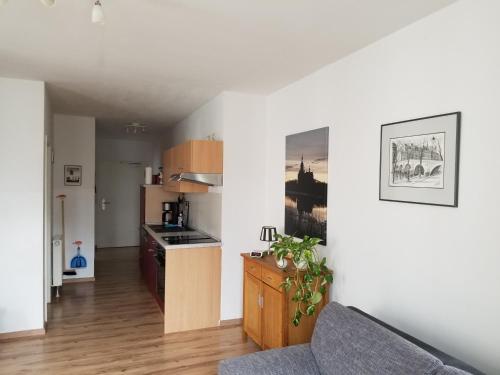 ein Wohnzimmer mit einem Sofa und einer Küche in der Unterkunft Altstadt Ferienwohnung Stralsund mit Parkplatz in Stralsund