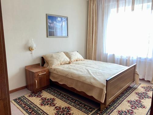 a bedroom with a bed and a window at Apartment in the centre of Karakol in Karakol