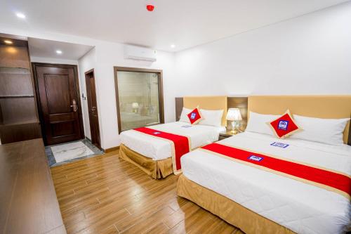 una camera d'albergo con due letti e un bagno di Khách Sạn Đại Dương FLC Sầm Sơn a Sầm Sơn