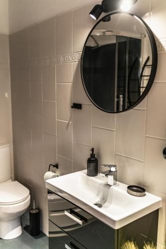 a bathroom with a white sink and a mirror at Apartament Sichlański in Murzasichle