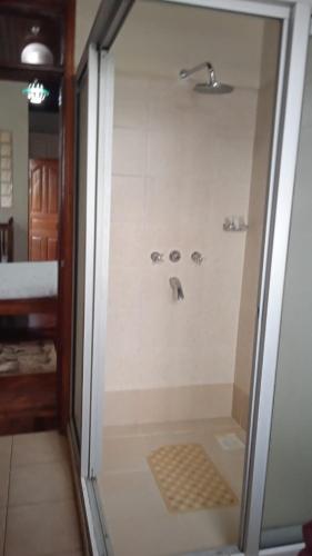 a shower with a glass door in a bathroom at dreamplace Gigiri in Nairobi