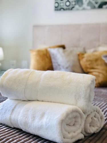 a stack of white towels sitting on a bed at Vista do Vale! 400 metros da Rua Coberta - Acomoda até 4 hóspedes in Gramado