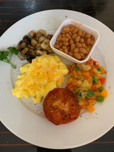 a plate of food with eggs vegetables and beans at Gerald's Gift Guest House in Addo